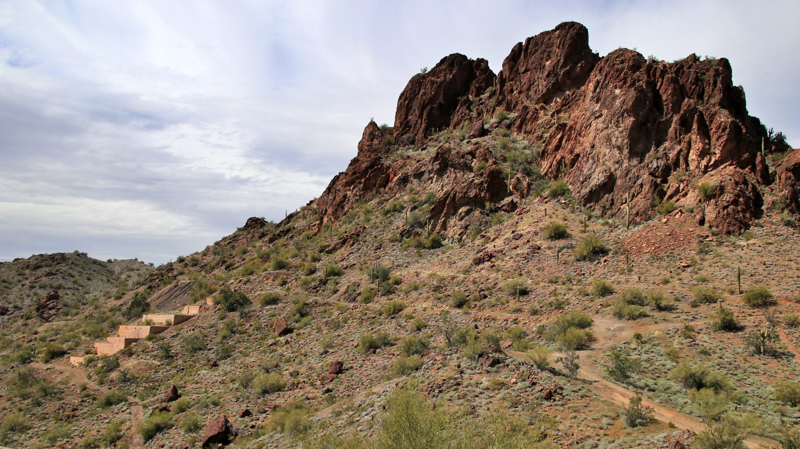 Belmont Mountains — Where Arizona Shows You Who’s Boss
Nestled about 50 miles west of Phoenix lies the Belmont Mountains — a 25-mile stretch of raw, rugged desert spine that meets the horizon with attitude. The highest point? Sugarloaf Mountain, rising ~3,418 ft, marking the crown of both the Belmonts and Hummingbird Springs terrain. 
But the real draw is Belmont Mountain Trail — our kind of playground. It’s not for the faint-hearted, but it’s not suicidal either. Think old mining roads, desert climbs, washes, and wild side spurs that whisper “you want to go that way?” 

What You’ll Get When You Roll With Us
Distance & Time: Around 13–16 miles of off-pavement terrain. Takes ~2–4 hours depending on how many detours you take.
Difficulty: Mostly moderate. The main route is doable in a high-clearance 4×4 (stock SUVs can usually hold their own). The optional side trails get spicy. 
Terrain & Features:
  • Sandy washes, rocky climbs, and eroded sections that’ll make you earn your line choices.
  • Historic mining remains — old shafts, ruins, mine foundations — plenty to poke around (but don’t go spelunking).
  • Broad desert vistas, sweeping views from higher ridgelines, and that kind of solitude that makes your skin tingle. 
Why We Love It — And You Will Too
Because this is a trail that gives back. You push a little, you get rewarded with views. You explore old mining history. You carve your own path through desert wash and rocky incline. There’s freedom in that.
It’s close enough to Phoenix to make it a solid half-day mission. But remote enough to feel like you’ve escaped civilization.

Pro Tips Before You Tag Along
1.Clearance is king — even though parts are mellow, some sections demand you keep your belly off the rocks.
2.Line choice matters — some washed out bits can bite you if you’re lazy.
3.Watch for rain — a little water turns washes into troublemakers.
4.Explore smart — those mining ruins are cool, but many shafts are unstable or fenced off. Respect the signs.
5.Bring the essentials — water, recovery gear, navigation, spare parts — treat the desert like a beast, not a backyard.